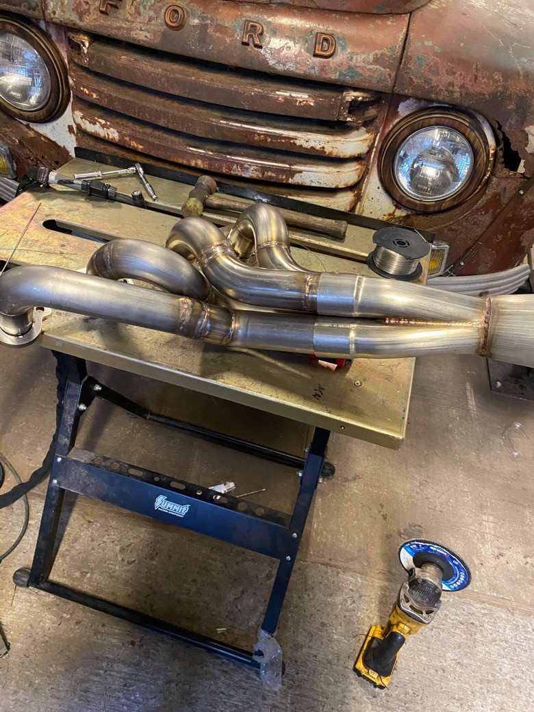 Custom fabricated stainless steel headers on a workbench