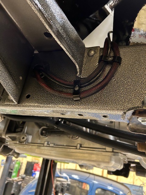 Custom automotive wiring harness routed and loomed along a frame rail