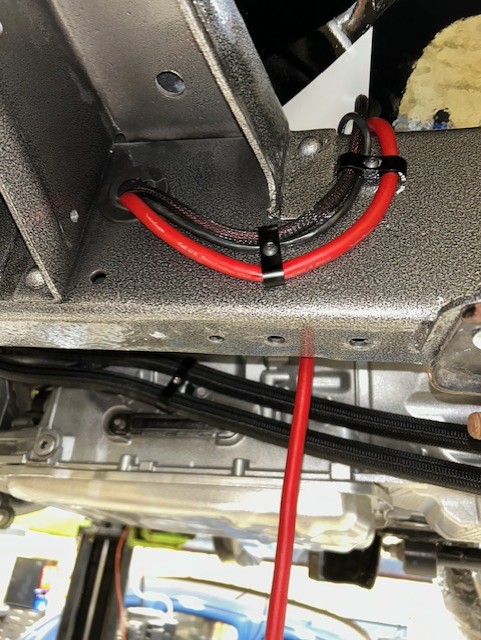 Red high-amperage cable secured along a powder-coated frame rail